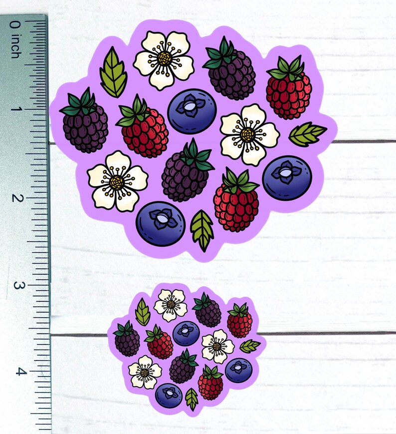 K&ouml;nnte beinhalten: Zwei violette Aufkleber mit wei&szlig;em Hintergrund, die verschiedene Beeren und wei&szlig;e Bl&uuml;ten zeigen. Die Beeren sind rot, blau und schwarz. Die Aufkleber haben die Form eines Kreises und einer Wolke.
