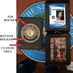 May include: Black leather badge holder with a gold seal featuring the state of Texas. The holder has two slots for badges or cards. The top slot has a badge with the text "New Technology, LLC" and the name "Lisa Turner, Program Manager". The bottom slot has a badge with the text "Lonestar Hero Gear" and the text "visit us at lonestarherogear.com".