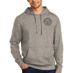 May include: A heather grey hooded sweatshirt with a black and white graphic of the State of Texas seal on the left chest.