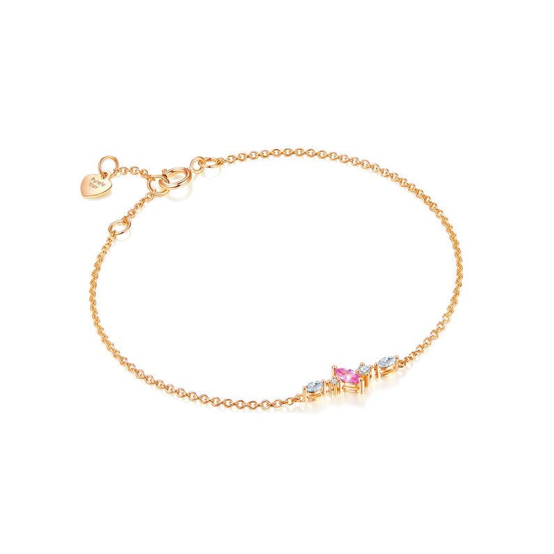 May include: A delicate gold chain bracelet with a small cluster of pink and white gemstones. The bracelet has a heart-shaped charm with the text "Forever & Ever" on it.