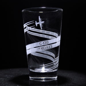 May include: A clear glass with a white etched design of a C-130 Hercules airplane and the text "C-130 HERCULES".