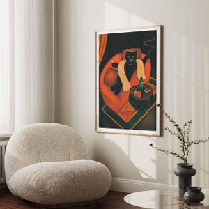 May include: A framed art print depicting a black cat in an orange armchair, wearing a fur stole and smoking. A small table beside the cat holds a bottle, cards, and a drink. The artwork has a vintage, illustrative style.