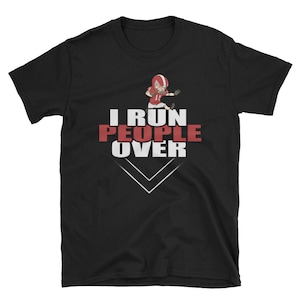 Puede incluir: Camiseta negra con un gráfico blanco de un jugador de fútbol americano corriendo y el texto "I run people over".