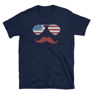 May include: A navy blue t-shirt with a red mustache and sunglasses with an American flag design.