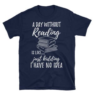 May include: A navy blue t-shirt with white text that reads "A day without reading is like... just kidding I have no idea". The text is surrounded by a stack of books.