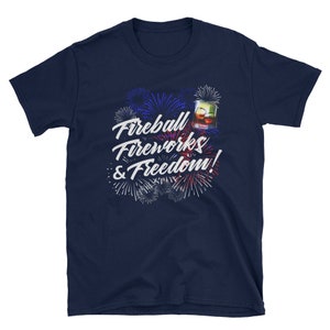 May include: Navy blue t-shirt with a white graphic of fireworks and a glass of Fireball whiskey. The text reads "Fireball Fireworks & Freedom!"