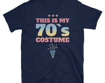 Puede incluir: Una camiseta azul marino con el texto "This is my 70's Costume" en colores arcoíris. Un gráfico de fuegos artificiales está debajo del texto.