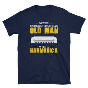 May include: Navy blue t-shirt with a white graphic that says "Never underestimate an old man with a harmonica". The graphic also includes a white harmonica.