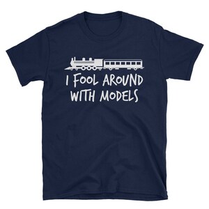 May include: A navy blue t-shirt with a white silhouette of a train and the text "I fool around with models".