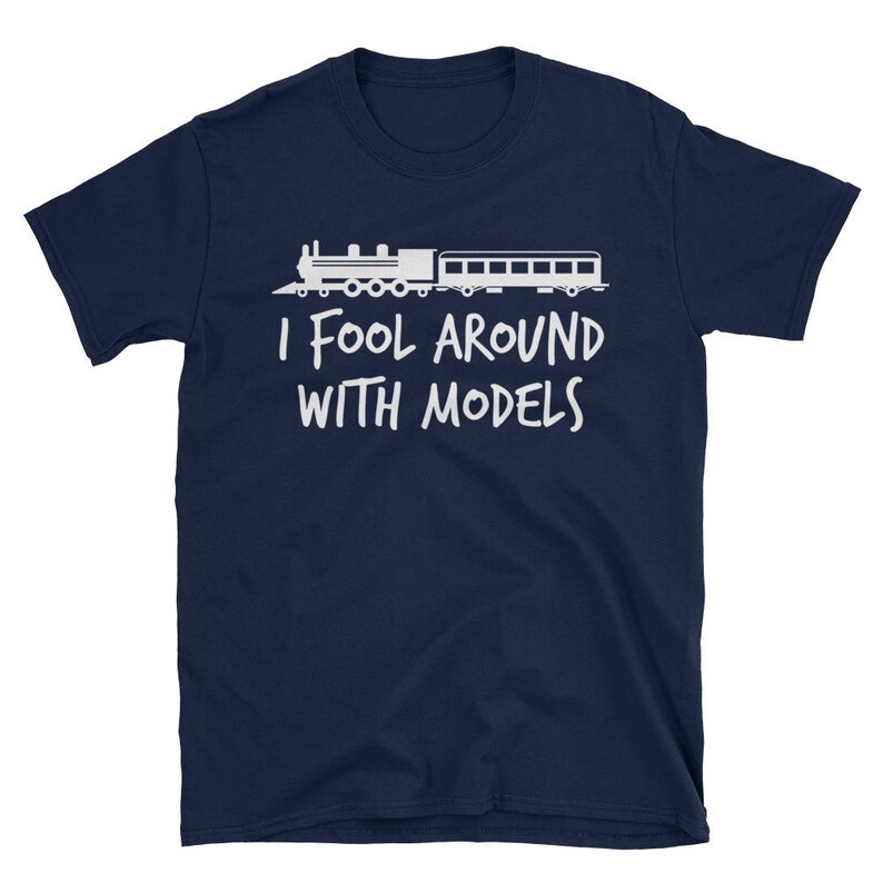 May include: A navy blue t-shirt with a white silhouette of a train and the text "I fool around with models".