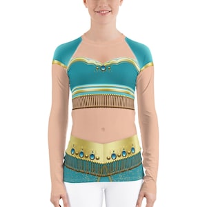 May include: A long-sleeved shirt with a teal and gold design inspired by a popular Disney princess. The shirt features a cropped top with a sweetheart neckline and a gold belt with blue gems.