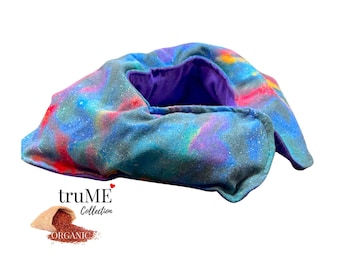 May include: A fabric wrap featuring a galaxy-inspired print with shades of blue, purple, and red, with a solid purple interior lining. The text "truME Collection" and "ORGANIC" appears below the wrap, accompanied by a small sack of grains.