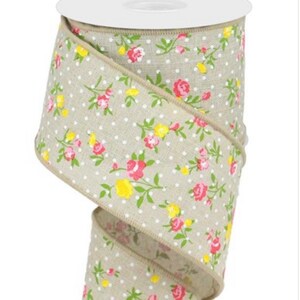 May include: A roll of beige fabric ribbon with a white polka dot pattern and a floral print in shades of pink and yellow.
