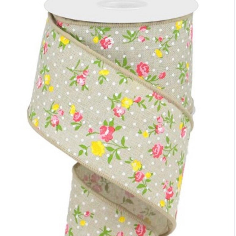 May include: A roll of beige fabric ribbon with a white polka dot pattern and a floral print in shades of pink and yellow.