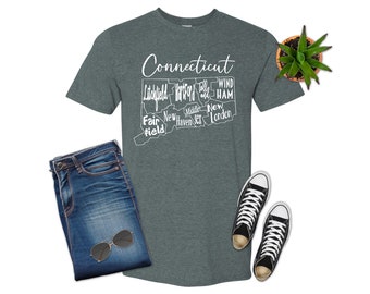 Może przedstawiać: Szary t-shirt w kolorze melanżu z białym obrysem stanu Connecticut i nazwami głównych miast w stanie. Tekst "Connecticut" jest napisany białym pismem ozdobnym u góry koszulki.