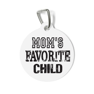 May include: White round tag with a silver metal ring. The tag has black text that reads "MOM'S FAVORITE CHILD" in a distressed font.