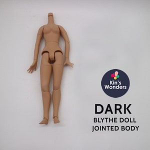 May include: A nude-colored plastic doll body with jointed arms and legs. The doll is missing its head. The doll is standing on a white surface. The text "DARK BLYTHE DOLL JOINTED BODY" is printed below the doll.