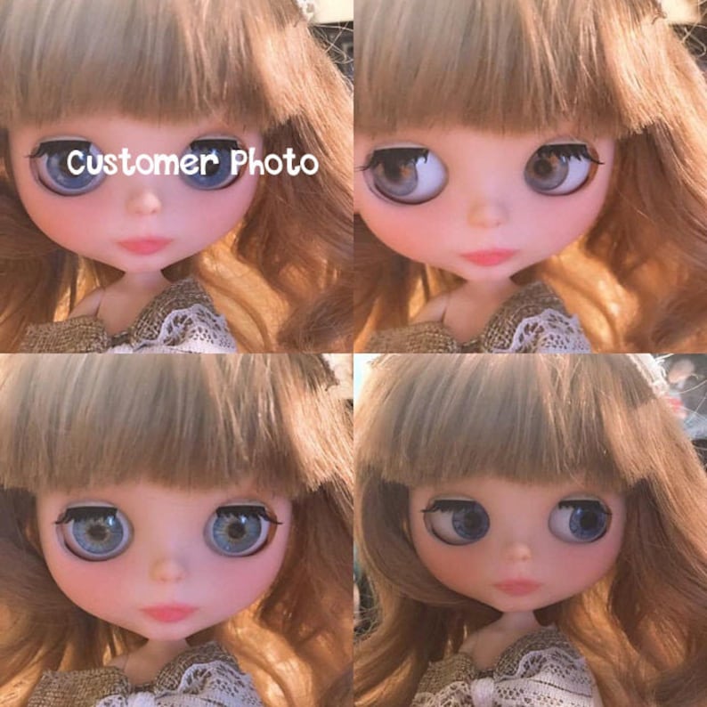 May include: A close-up of a doll with long, wavy, light brown hair. The doll has blue eyes and is wearing a brown and white dress. The doll's face is painted with a delicate blush and a light pink lip color. The doll's eyes are large and expressive, and the doll's overall appearance is sweet and innocent.