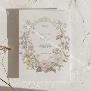 Puede incluir: Invitaci&oacute;n de boda con un dise&ntilde;o de corona floral con flores rosas, amarillas y blancas. El texto dice "Join us for the wedding of Michael & Sarah", con la fecha y los detalles del lugar. La invitaci&oacute;n tiene un estilo cl&aacute;sico y elegante.