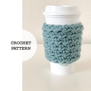 May include: A teal blue crocheted coffee cup cosy. The cosy is made with a simple stitch pattern and is perfect for keeping your hands warm while enjoying your favourite beverage.
