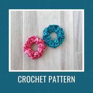 May include: Two crocheted hair scrunchies, one pink and white and one blue and white, on a white wooden surface. CROCHET PATTERN is written below the scrunchies.