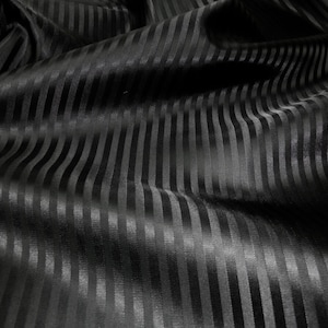 May include: Black fabric with a striped pattern. The fabric is smooth and has a subtle sheen.