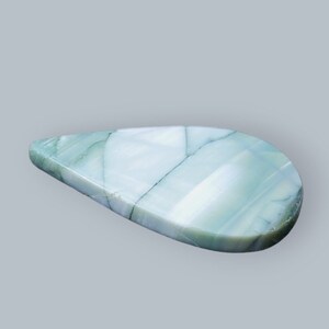 Może przedstawiać: Kropla zielonego i białego agatu o gładkiej, wypolerowanej powierzchni.