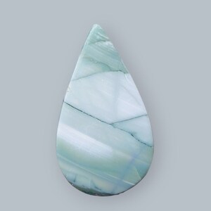 Puede incluir: Un cabujón de ágata verde y blanca en forma de lágrima con un patrón de remolino.