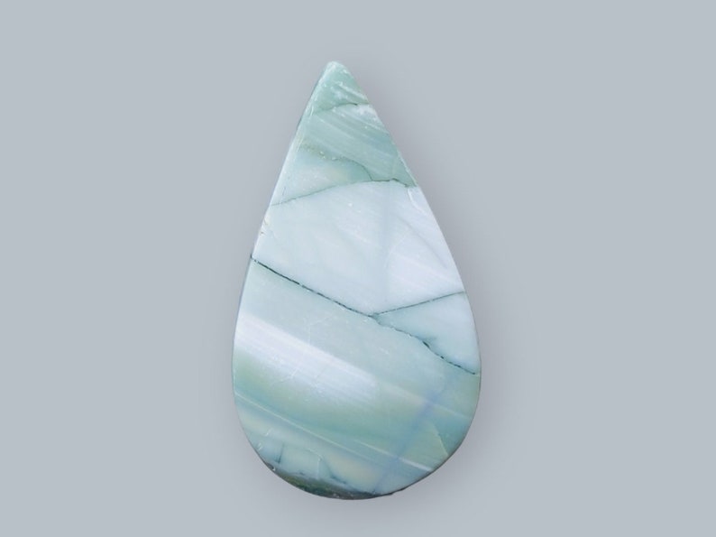 Może przedstawiać: Kabochoński kamień agatu w kształcie łzy, w kolorze zielonym i białym, z wirującym wzorem.
