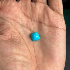 May include: A bright turquoise gemstone with a square shape.