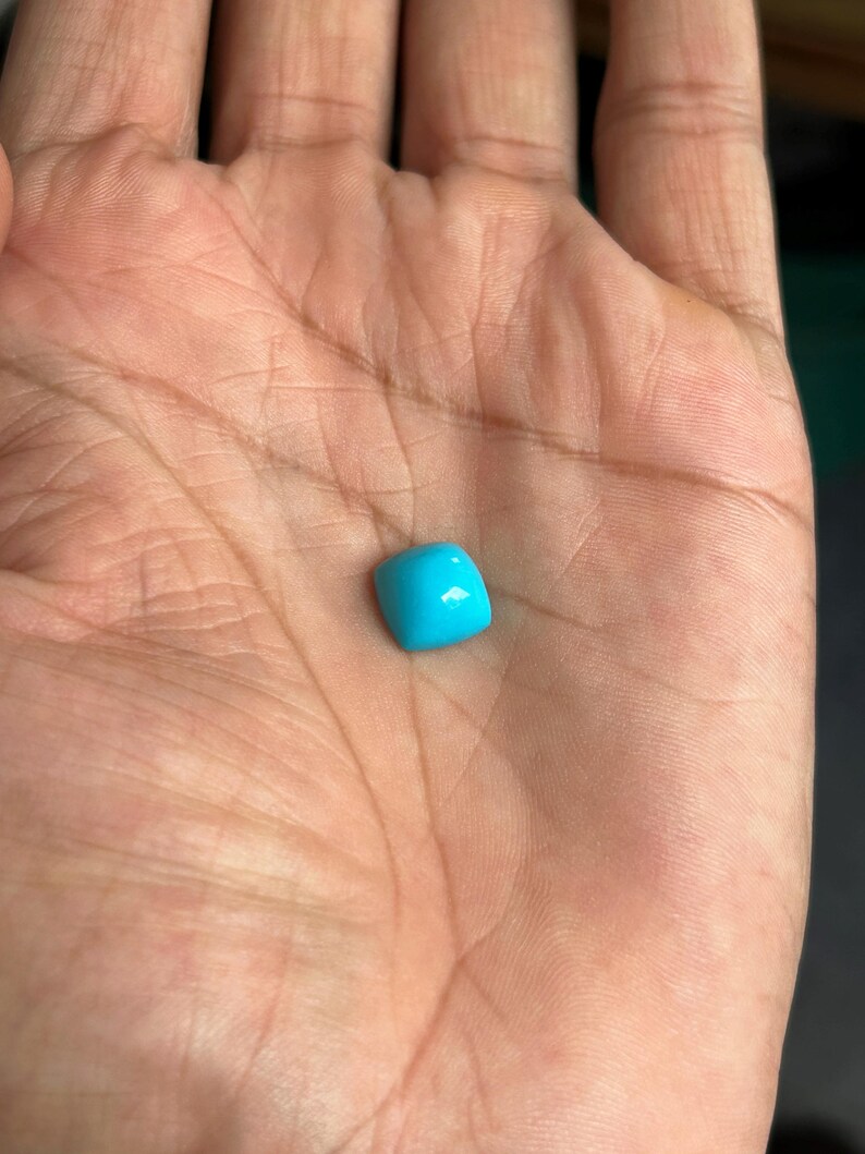 May include: A bright turquoise gemstone with a square shape.