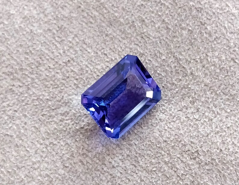 K&ouml;nnte beinhalten: Ein tiefblauer Edelstein mit einem rechteckigen Smaragdschliff.