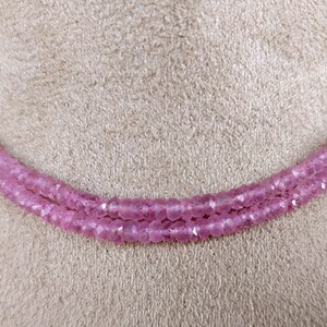 Pode incluir: Um colar de duas voltas feito de contas de pedras preciosas cor-de-rosa. As contas s&atilde;o facetadas e t&ecirc;m uma cor rosa claro.
