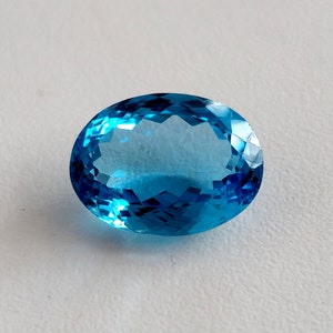 May include: A bright blue oval-shaped gemstone with a faceted cut.