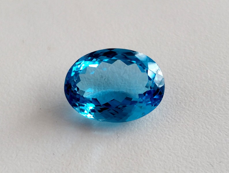 May include: A bright blue oval-shaped gemstone with a faceted cut.