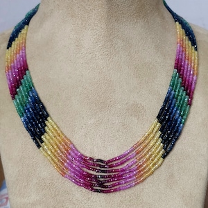 Peut inclure: Collier multi-rangs composé de perles de pierres précieuses colorées. Le collier présente un arc-en-ciel de couleurs, notamment le rouge, l'orange, le jaune, le vert, le bleu et le violet.