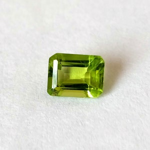 Peut inclure: Une pierre précieuse de péridot verte taillée en forme d'émeraude.
