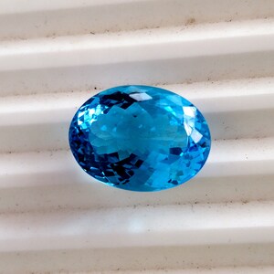 May include: A bright blue oval-shaped gemstone with a faceted cut.