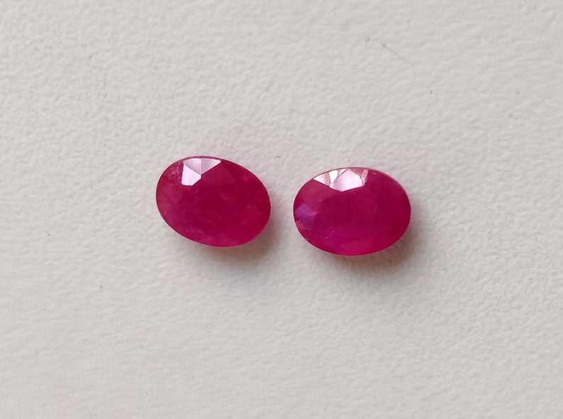 Puede incluir: Dos piedras preciosas de rub&iacute; de forma ovalada y facetadas. Los rub&iacute;es son de un color rojo intenso y rico.