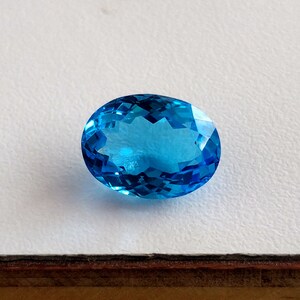 May include: A bright blue oval-shaped gemstone with a faceted cut.