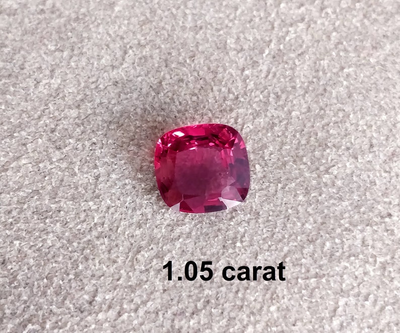 Pode incluir: Uma gema rosa vibrante, cortada em forma quadrada, com acabamento polido. A gema tem 1,05 quilates.