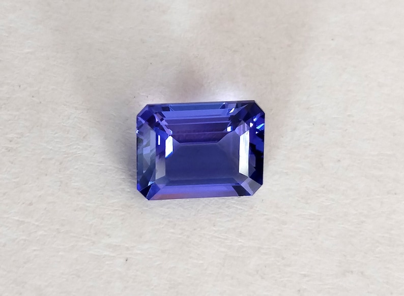 K&ouml;nnte beinhalten: Ein tiefblauer Edelstein mit einem rechteckigen Smaragdschliff.