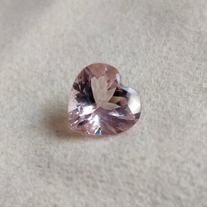 Op de afbeelding: Een hartvormige roze edelsteen met een facetgeslepen vorm.