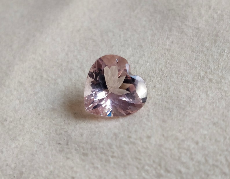 Op de afbeelding: Een hartvormige roze edelsteen met een facetgeslepen vorm.