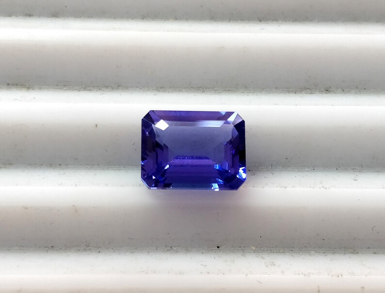 K&ouml;nnte beinhalten: Ein tiefblauer, rechteckiger Edelstein im Smaragdschliff.