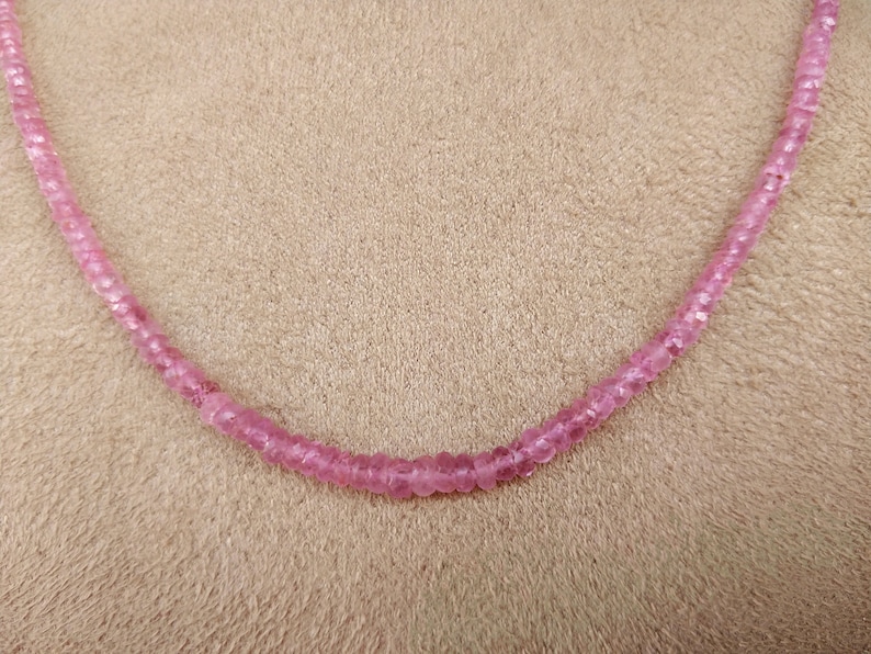 Pode incluir: Um colar de pedras preciosas cor-de-rosa com pequenas contas redondas.