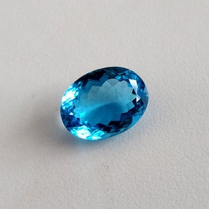 May include: A bright blue oval-shaped gemstone with a faceted cut.