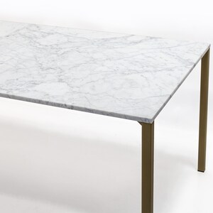 Puede incluir: Una mesa de comedor rectangular con una tapa de m&aacute;rmol blanco y patas de metal dorado.
