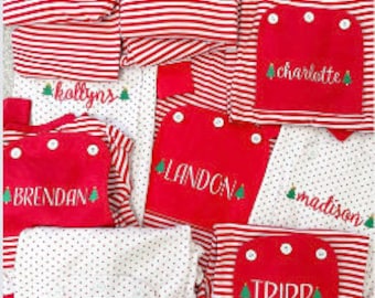 May include: A collection of red and white striped pajamas with green Christmas trees and personalized names, including "Brendan", "Catherine", "Charlotte", "Tripp", "Landona", "Madison", "Kollyns", and "Kyle".