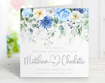 May include: A wedding card with blue and white watercolor flowers. The card says "To a special brother and sister in law Matthew Charlotte On your wedding day Sunday 4th June 2023".